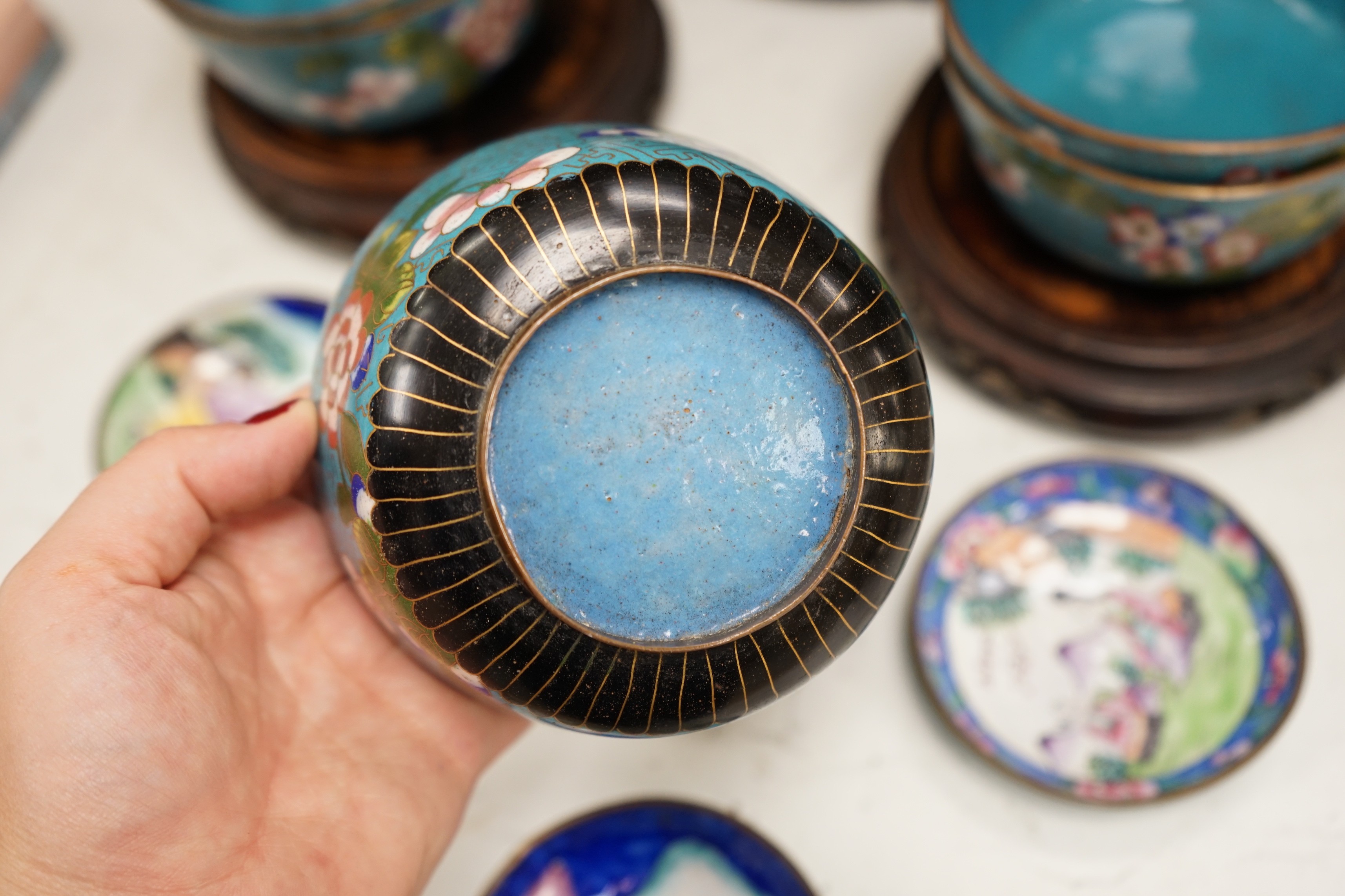 A Chinese cloisonné enamel 'dragon' bowl, six Chinese floral cloisonné enamel bowls and four Canton enamel dishes and wood stands